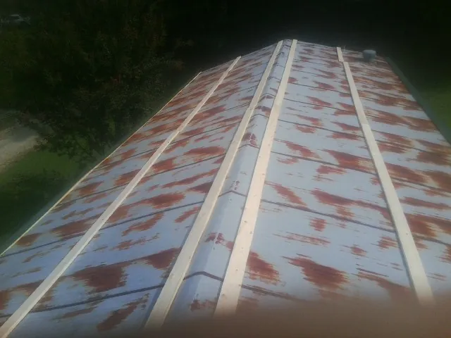Rusted metal roof panels with new wood purlins before replacement — Storm Damage Roof Repair in Lenoir City by Roofing Brothers