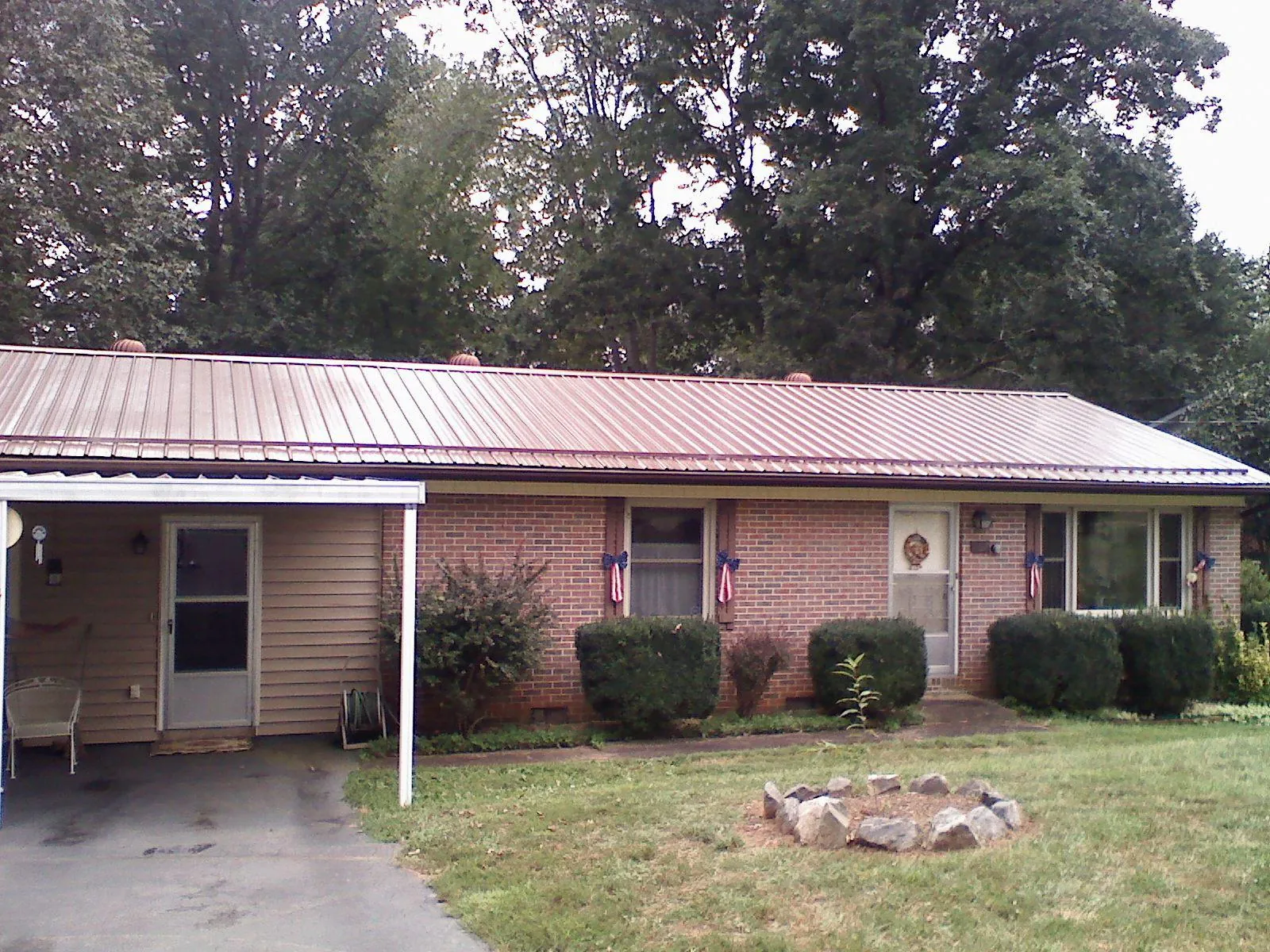 Bronze metal roof and carport on a brick ranch home — Roof Repair work by our crew in Lenoir City