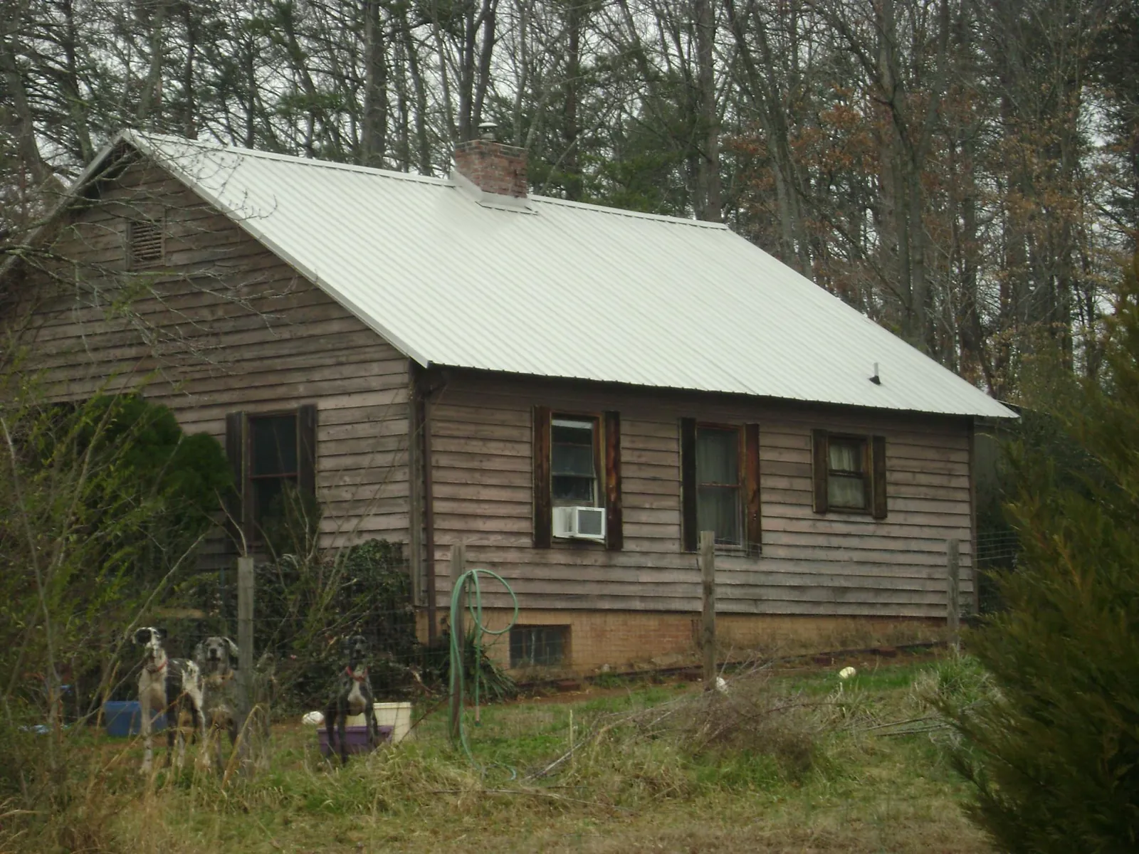 White metal roof on an old wood sided farmhouse, from a Asphalt Shingle Roof Repair job in Lenoir City